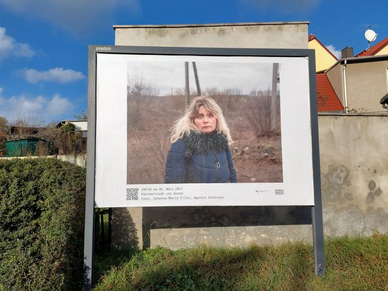 Das Foto auf einer Werbetafel zeigt eine Frau in Irpin während des Ukraine-Kriegs.