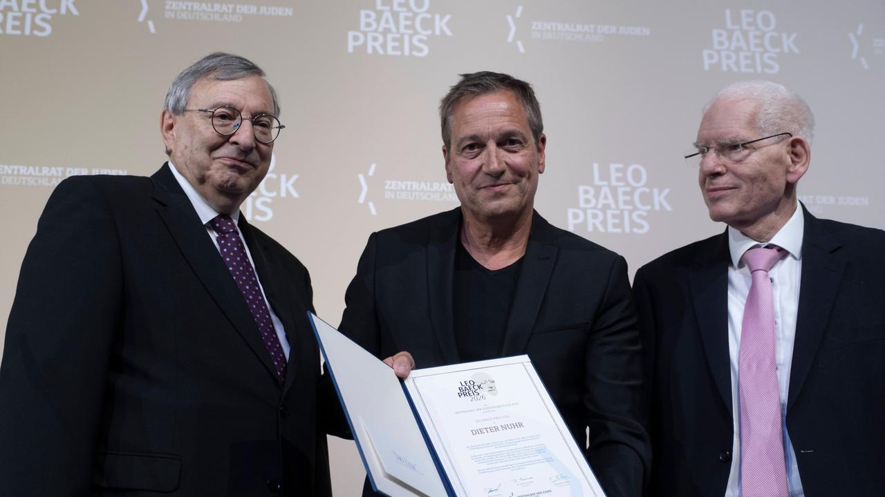 Zu sehen sind links Abraham Lehrer, Vizepräsident des Zentralrats der Juden in Deutschland, in der Mitte Dieter Nuhr mit der Auszeichnung in den Händen und rechts Josef Schuster, Präsident des Zentralrats der Juden in Deutschland. 