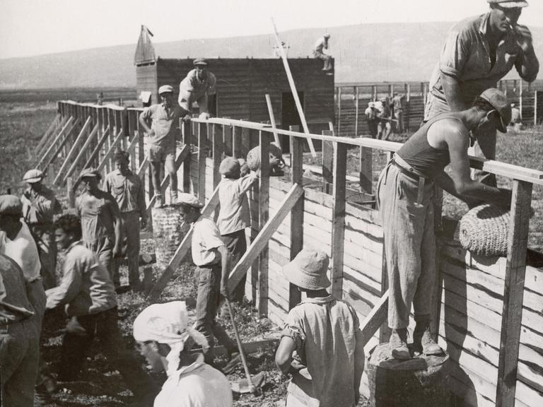Jüdische Siedler in Palästina: Bau von kugelsicheren, festungsartigen Schutzwänden einer neuen jüdischen Bauernsiedlung. Photographie von Zoltan Kluger. 1935.