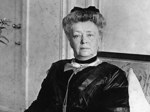 Bertha von Suttner in einer Fotoaufnahme: Sie sitzt auf einem Foto und blickt in die Kamera