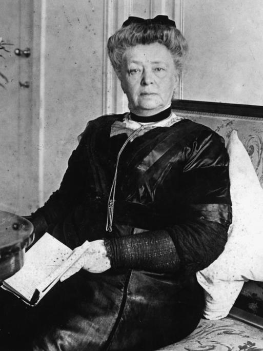 Bertha von Suttner in einer Fotoaufnahme: Sie sitzt auf einem Foto und blickt in die Kamera
