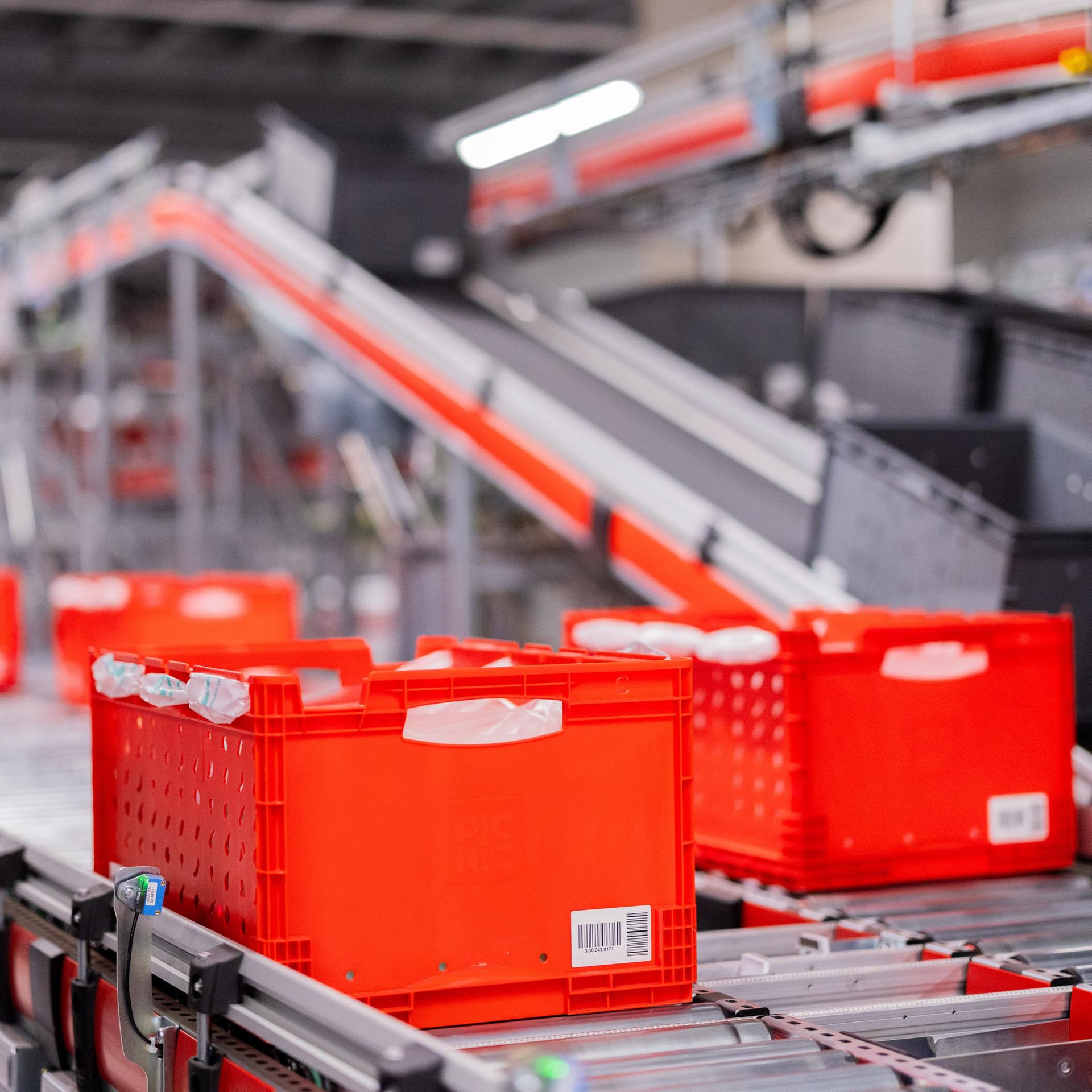 Kisten mit Lebensmitteln fahren im automatisierten Lager des Lebensmittel-Lieferdienstes Picnic.