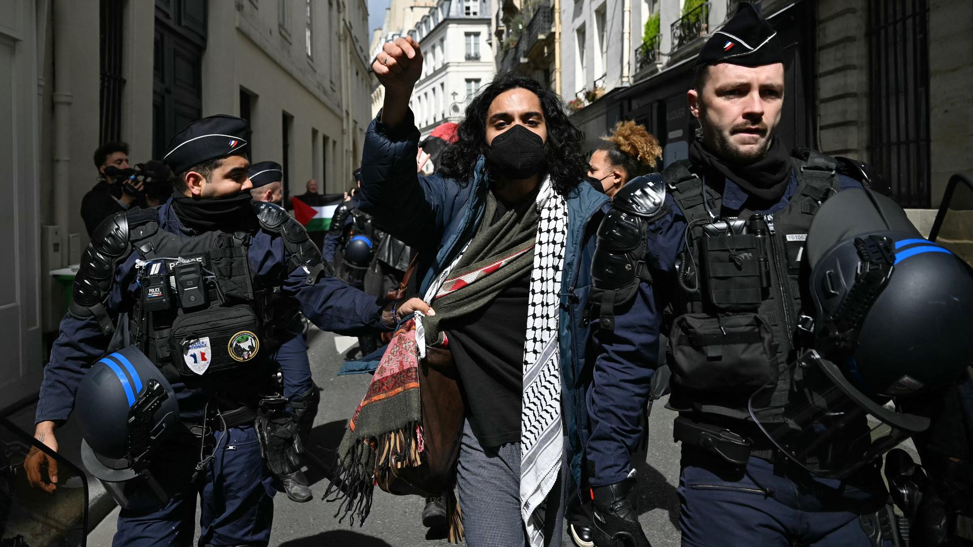 Ein Demonstrant mit Palästinenser-Schal wird von zwei Polizisten festgenommen und forteskortiert. Ein Demonstrant mit Palästinenser-Schal wird von zwei Polizisten festgenommen und forteskortiert.