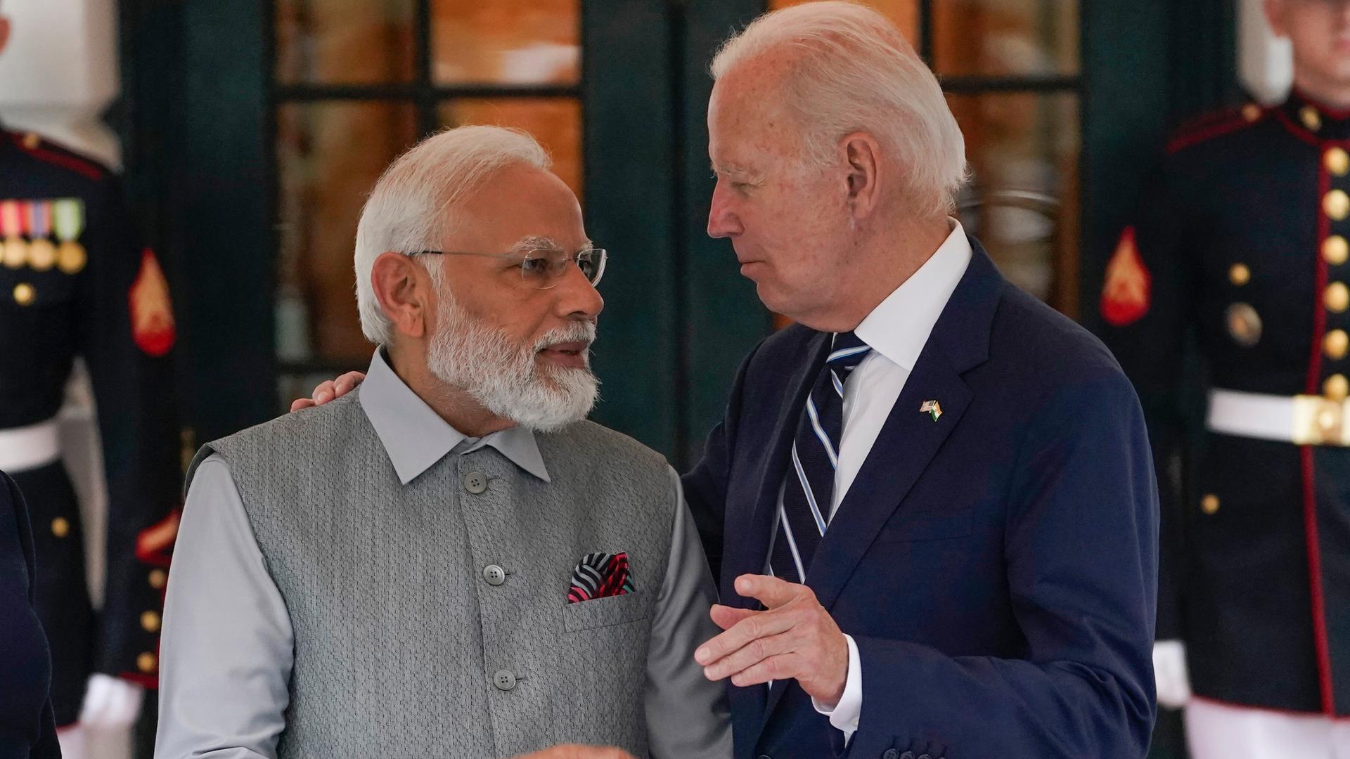 Joe Biden und Narendra Modi stehen einander zugewandt und unterhalten sich mit freundlichen Gesichtsausdrücken.