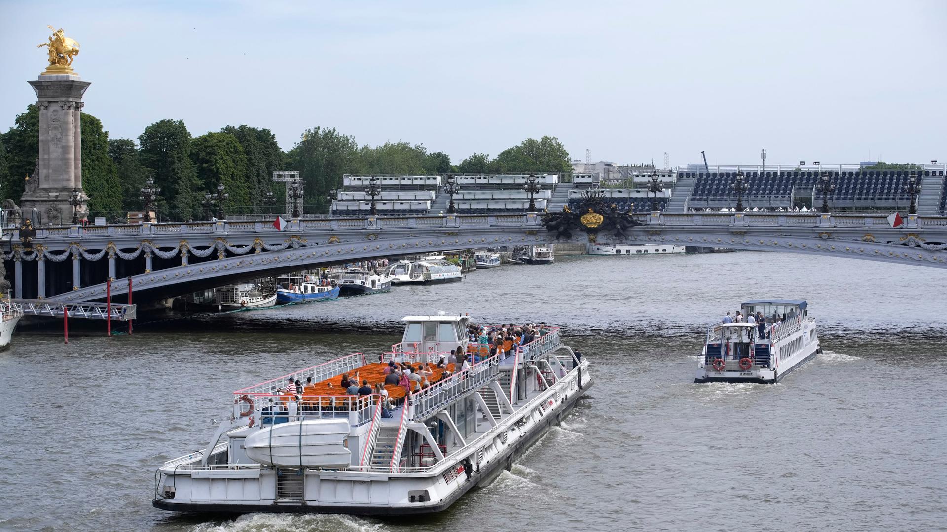 Ausflugsschiffe waren in Paris auf dem Fluss Seine und passieren die Brücke Pont Alexandre III.