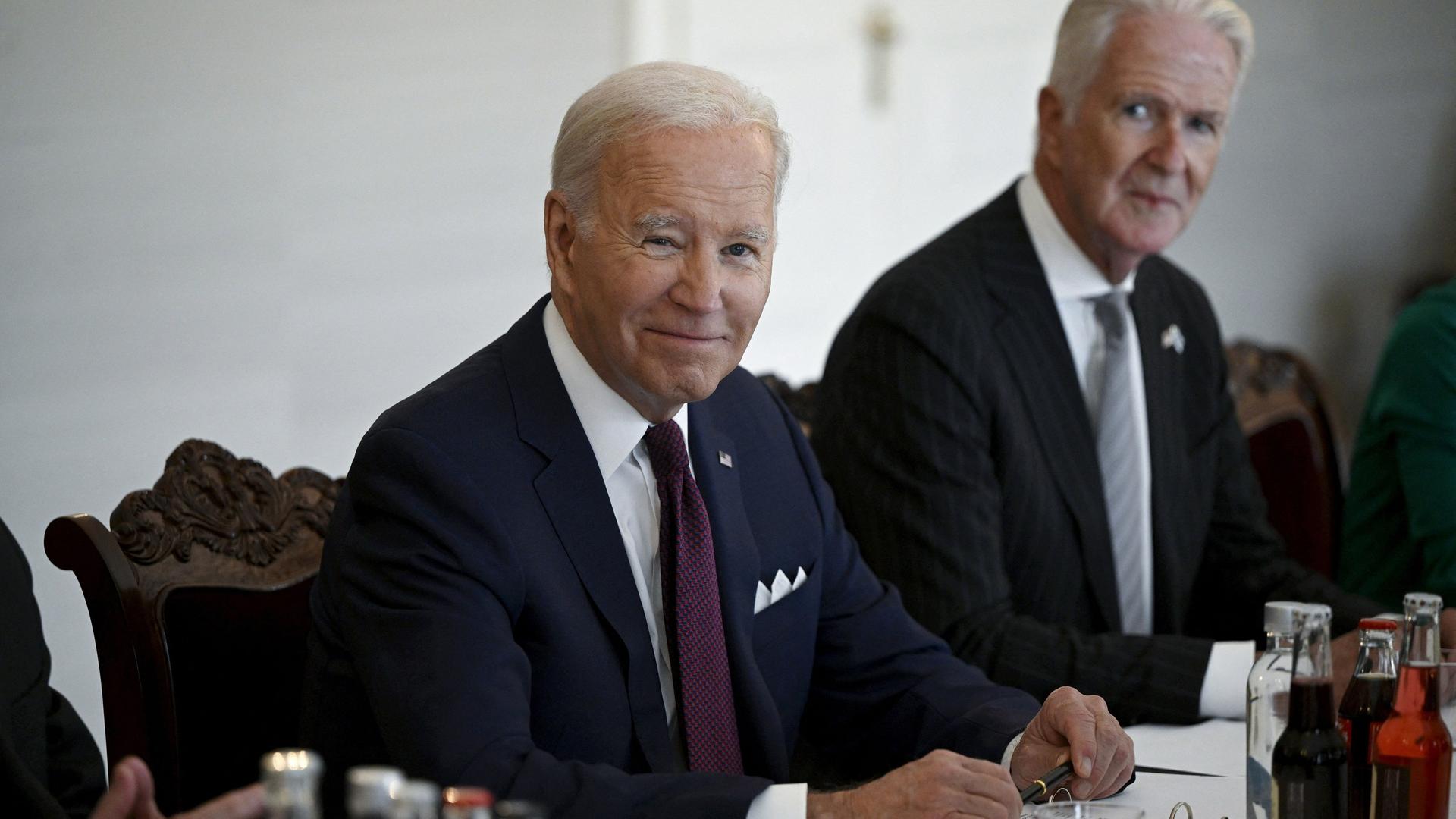 US-Präsident Biden zu Besuch beim finnischen Präsidenten Niinistö. Die beiden Politiker sitzen lächelnd an einem Tisch. US-Präsident Biden zu Besuch beim finnischen Präsidenten Niinistö. Die beiden Politiker sitzen lächelnd an einem Tisch.