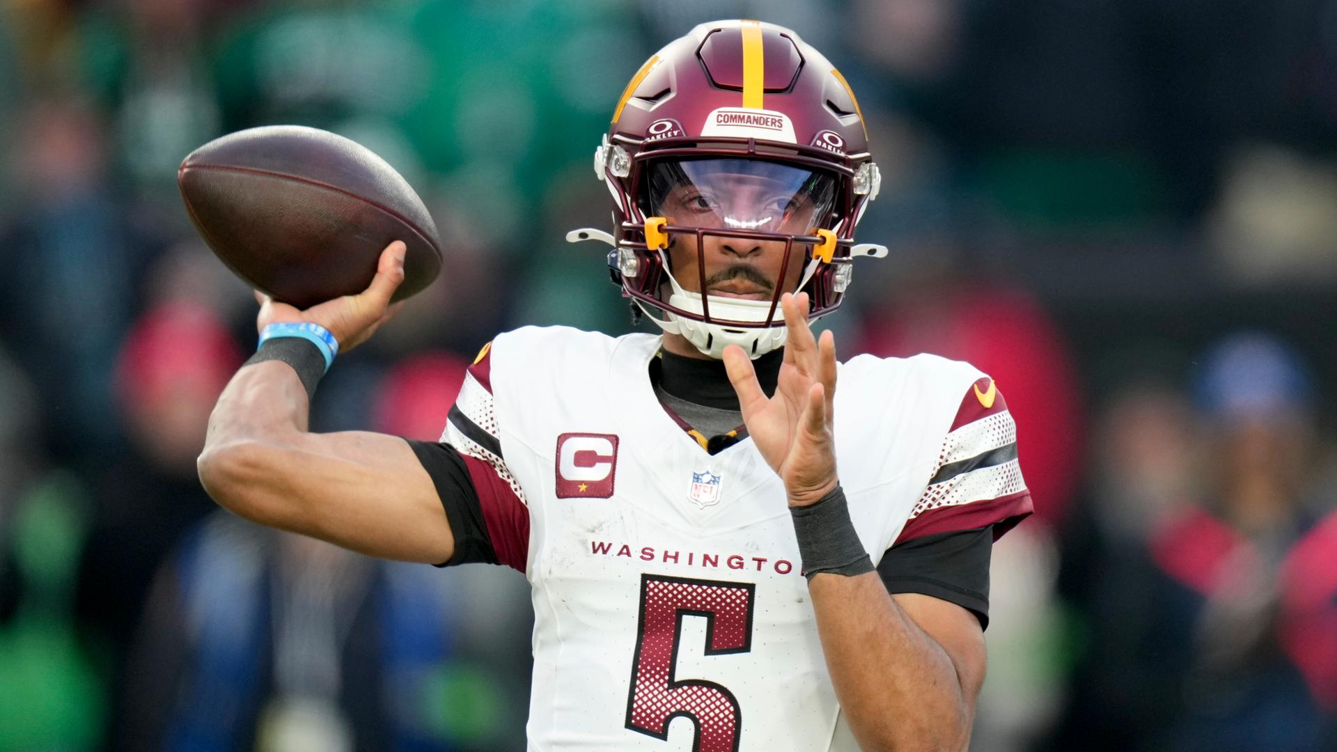 NFL-Profi Jayden Daniels im Trikot der Washington Commanders mit einem Football in der Hand NFL-Profi Jayden Daniels im Trikot der Washington Commanders mit einem Football in der Hand