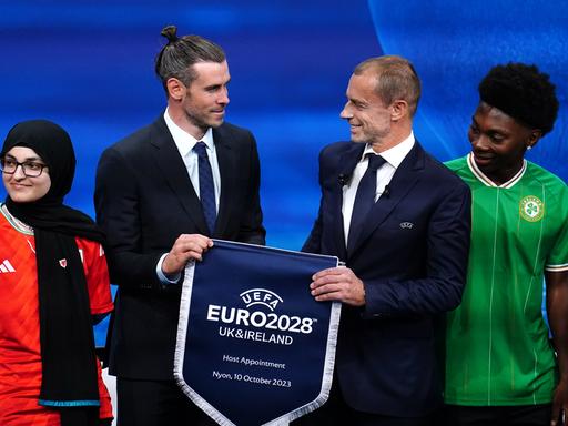 Der walisische Delegierte und Ex-Fußballer Gareth Bale und UEFA-Präsident Aleksander Ceferin halten während der Ankündigungszeremonie der Gastgeber der Euro 2028 und Euro 2032 im UEFA-Hauptquartier in Nyon, Schweiz, einen Wimpel der UEFA Euro 2028 in der Hand.