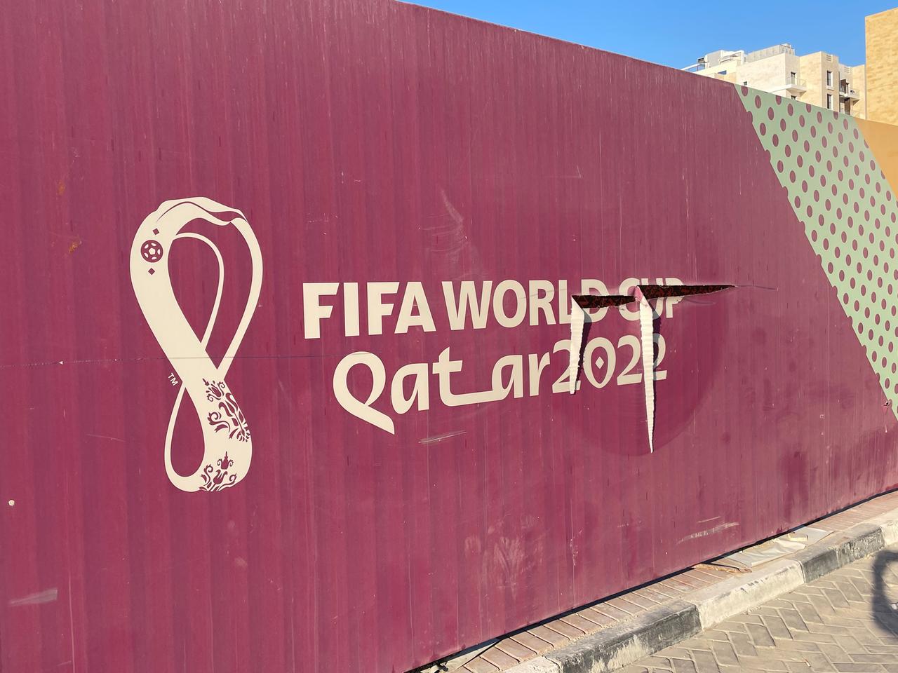 Zu sehen ist eine Aufnahme von einer vergilbten WM-Werbung beim Lusail-Stadion in Katar.