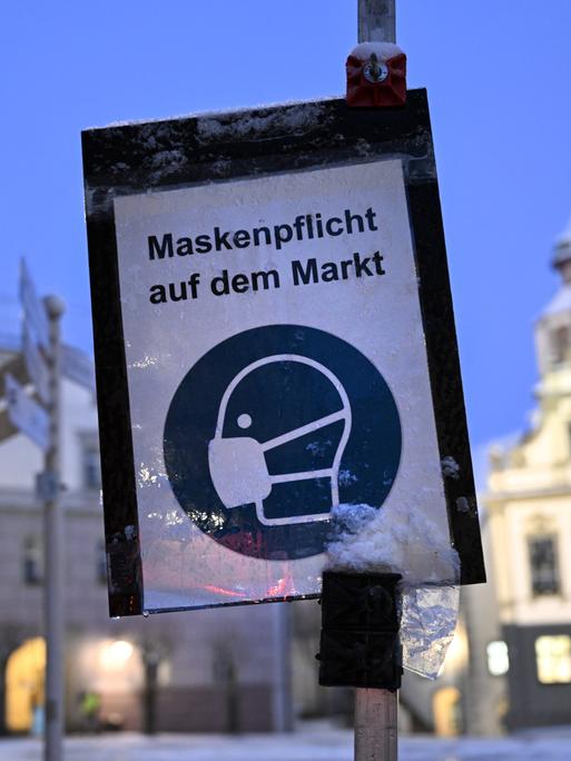 Ein Schild im Januar 2022 wies aufgrund der Corona-Pandemie auf die Maskenpflicht auf dem Marktplatz von Wangen im Allgäu hin.
