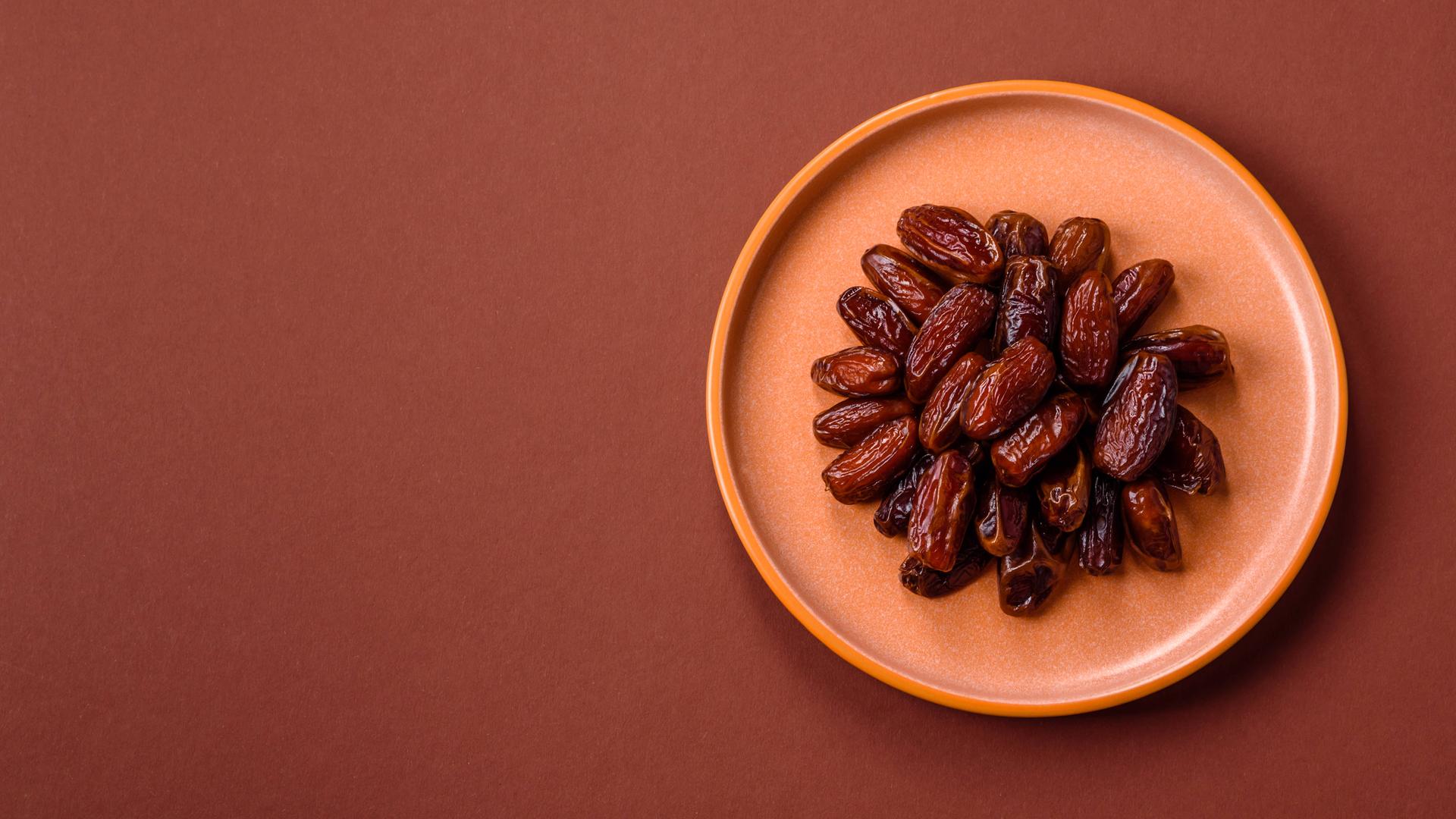 Getrocknete Datteln in einem Keramikteller, arabisches Essen für den Ramadantisch. 