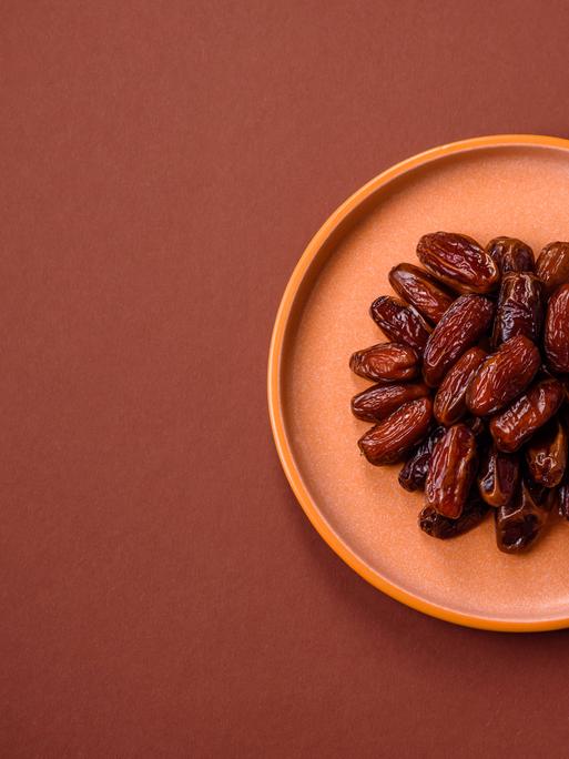 Getrocknete Datteln in einem Keramikteller, arabisches Essen für den Ramadantisch. 