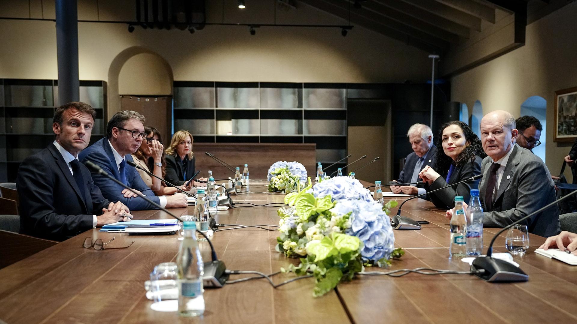 Das Foto zeigt vier Politiker an einem TIsch. Es handelt sich um Frankreichs Präsident Emmanuel Macron (l-r), Aleksandar Vucic, Präsident der Republik Serbien, Vjosa Osmani-Sadriu, Präsidentin der Republik Kosovo, und Bundeskanzler Olaf Scholz.