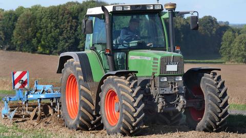 Auf einem Acker in Wennerode am Harz im Bundesland Niedersachsen, grubbert ein Traktor mit einem Schwergrubber schweres Harzer Ackerland.