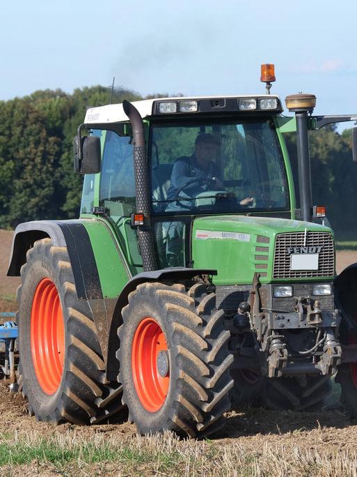 Auf einem Acker in Niedersachsen bestellt ein Landwirt mit seinem Traktor das Feld.