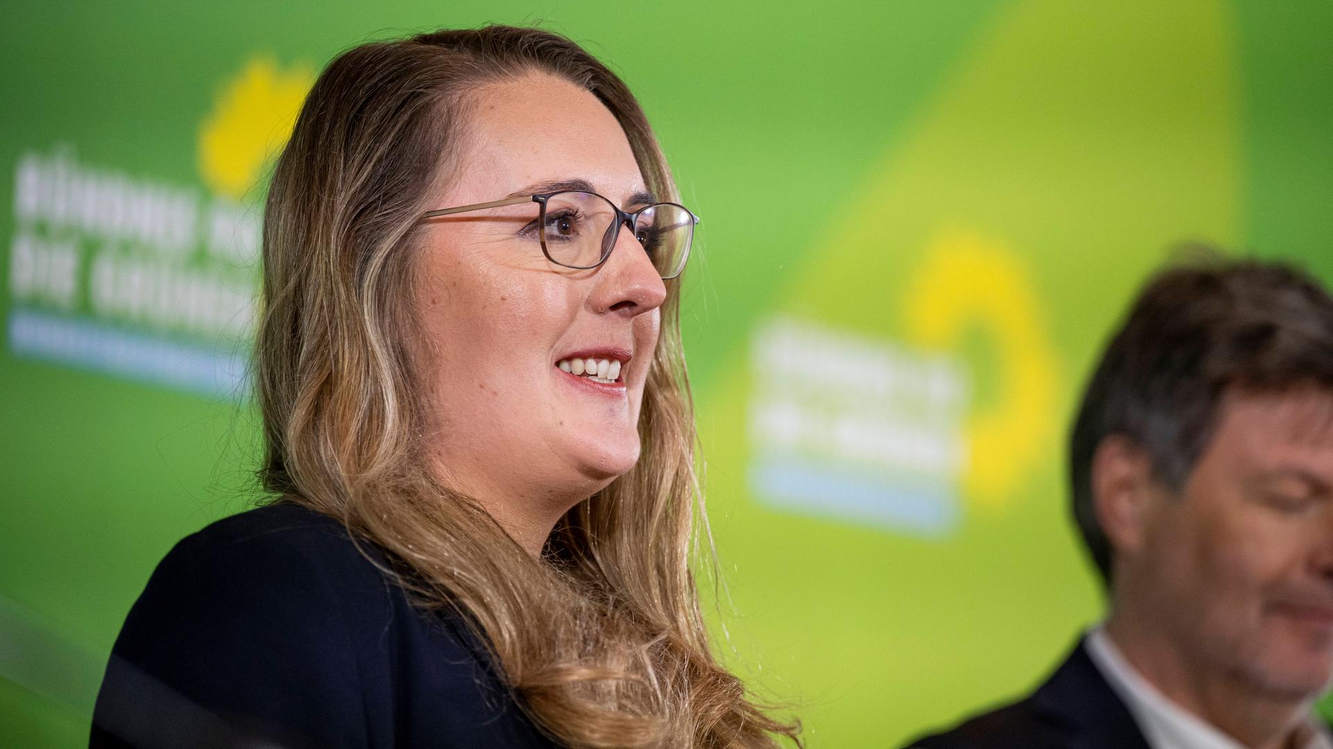 Katharina Dröge (Grüne) lächelt, neben ihr steht Robert Habeck