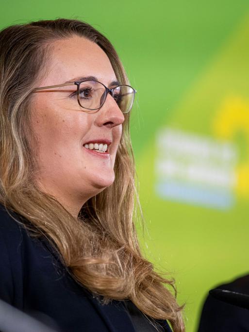 Katharina Dröge (Grüne) lächelt, neben ihr steht Robert Habeck