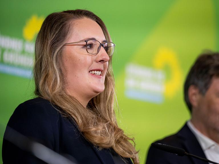 Katharina Dröge (Grüne) lächelt, neben ihr steht Robert Habeck