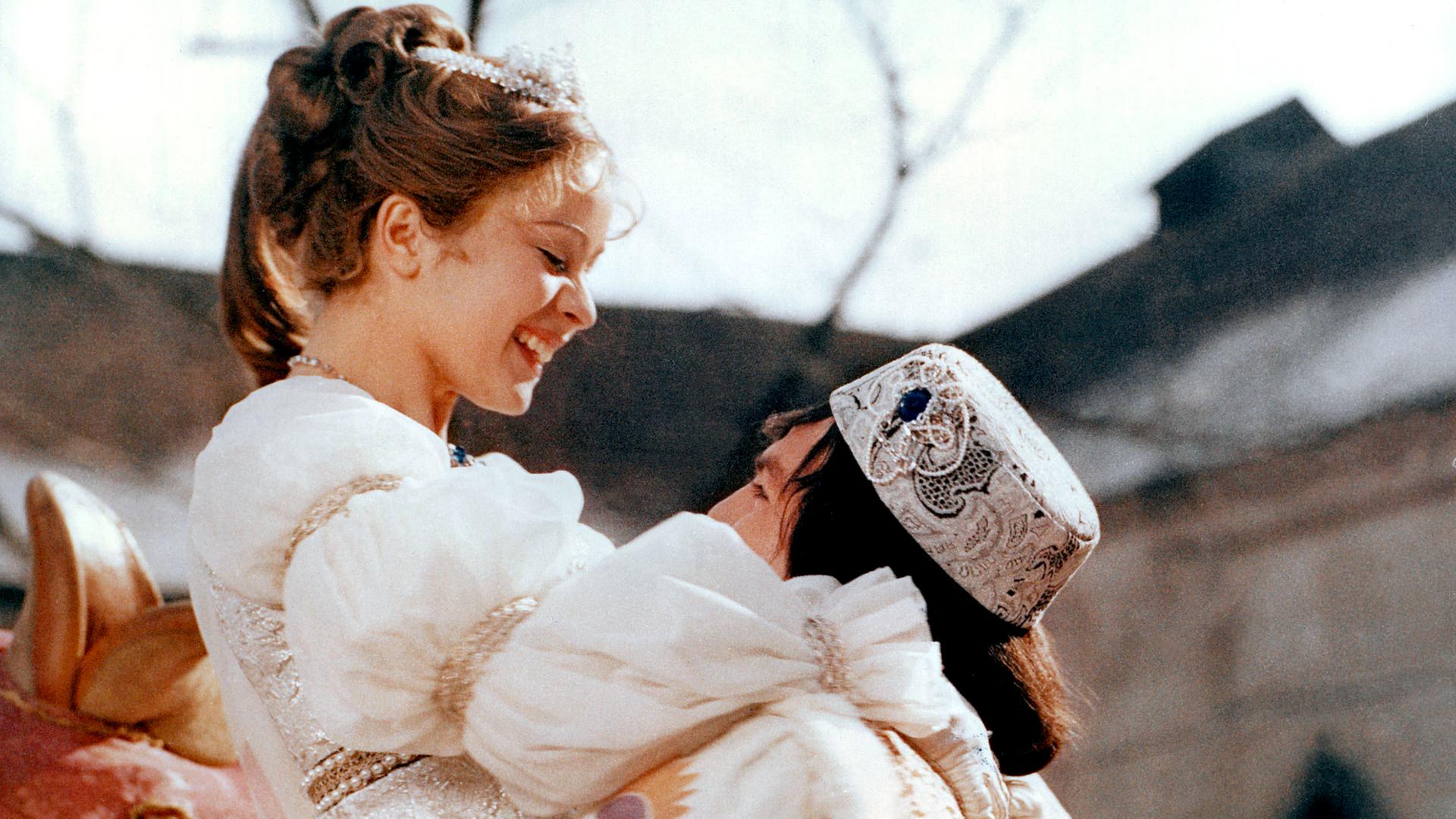 Filmszene aus "Drei Haselnüsse für Aschenbrödel": Der festlich gekleidete Prinz hält die Prinzessin in weißem Prachtkleid hoch.