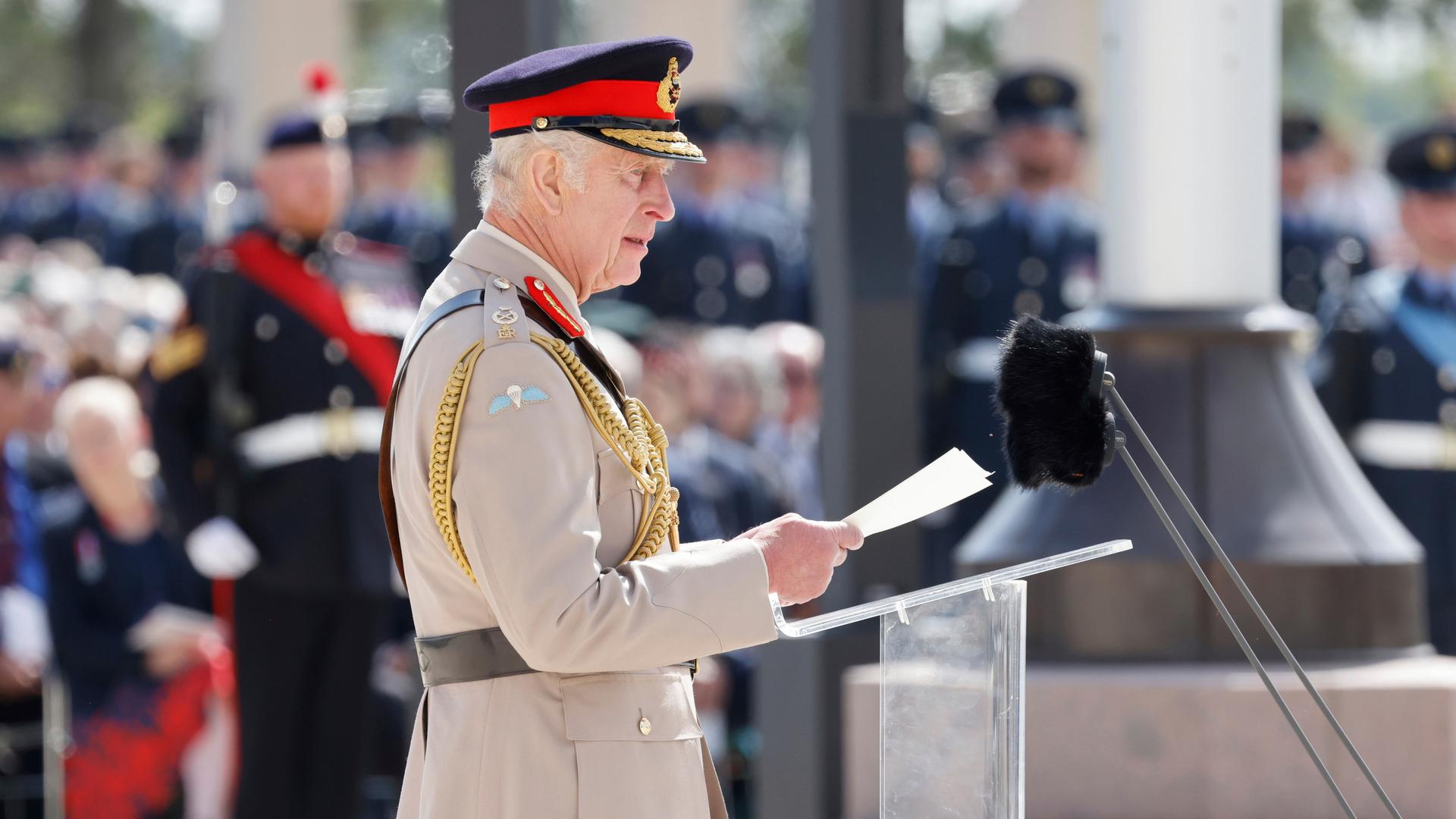 Der britische König Charles III. spricht während einer Gedenkveranstaltung zum 80. Jahrestag der Landung der Alliierten in der Normandie an einem Rednerpult und trägt beige-farbende Uniform.