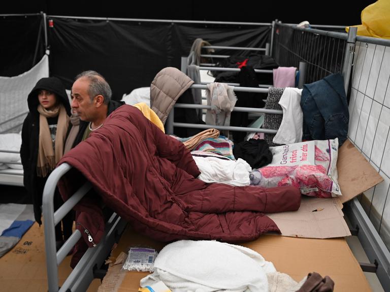 Eine aus dem Irak geflüchtete Familie steht in einem der Zelte der Flüchtlingsunterkunft in ihrer Wohnparzelle in Bensheim. 