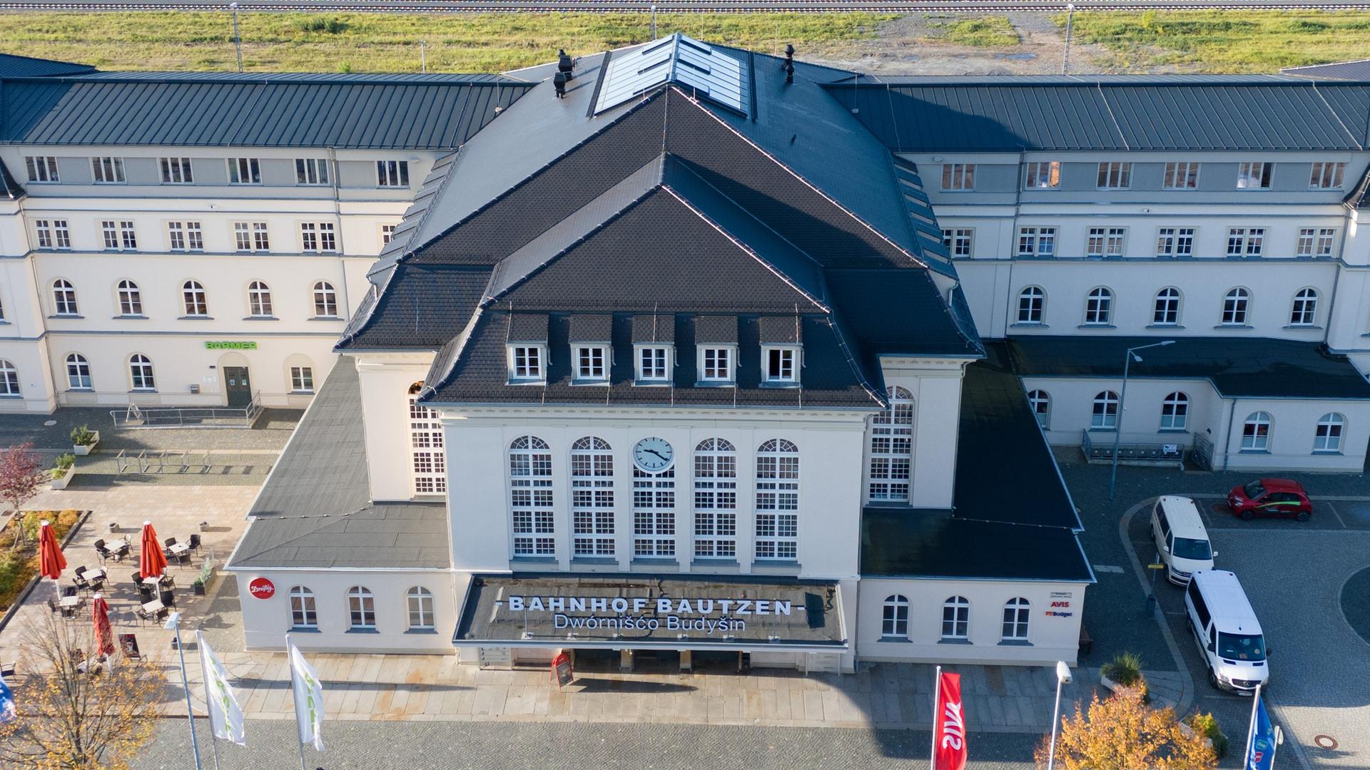 Autos stehen auf einem Parkplatz vor dem Bahnhof Bautzen (Aufnahme mit einer Drohne).