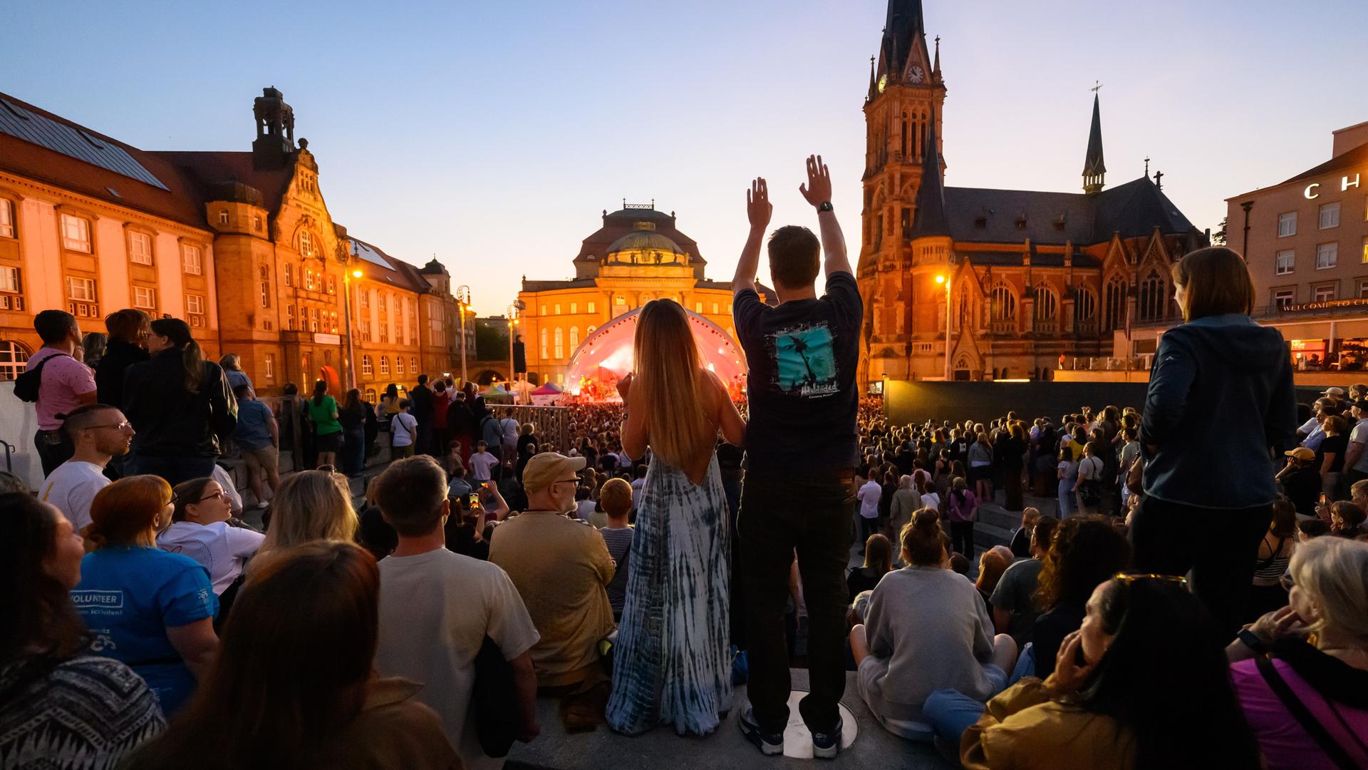Das Publikum tanzt auf einem öffentlichen Stadtplatz zum Konzert von Kraftklub. Das Publikum tanzt auf einem öffentlichen Stadtplatz zum Konzert von Kraftklub.