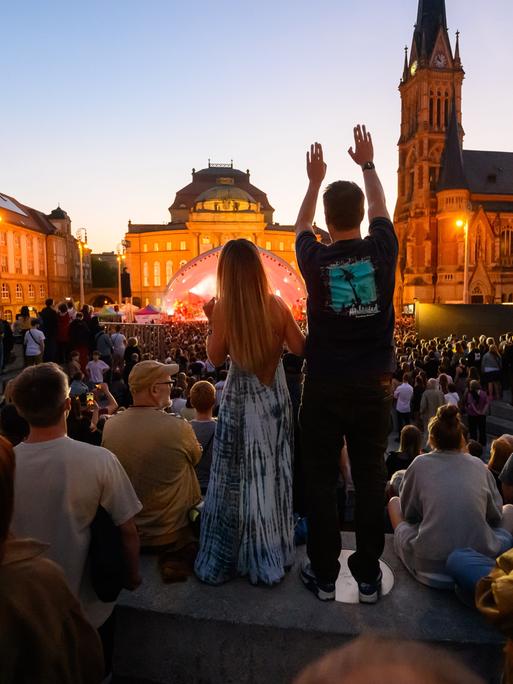 Das Publikum tanzt auf einem öffentlichen Stadtplatz zum Konzert von Kraftklub.