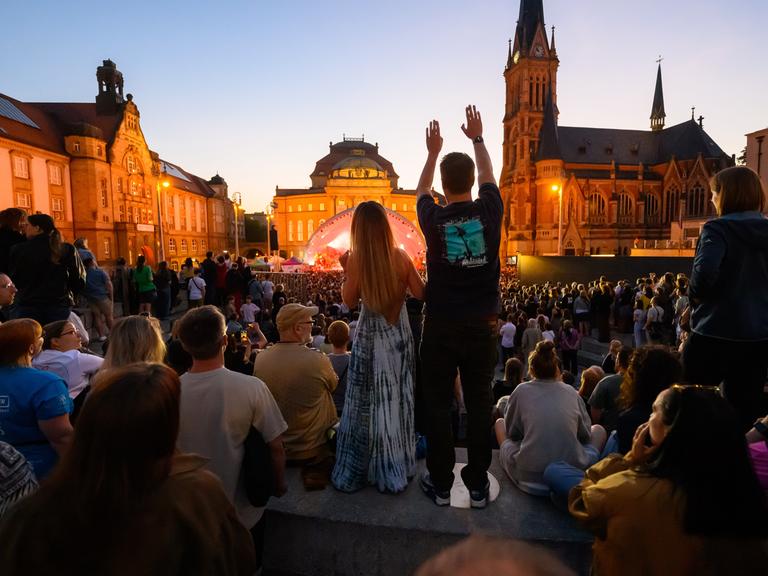 Das Publikum tanzt auf einem öffentlichen Stadtplatz zum Konzert von Kraftklub.