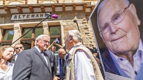 Bundespräsident Frank-Walter Steinmeier spricht mit Personen bei der Eröffnung der Freilichtausstellung "We AHR strong. Fünf Jahre, ein neuer Blick" in Altenahr.