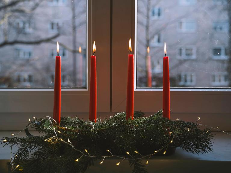 Tannenzweige und Kerzen für eine weihnachtsliche Stimmung.