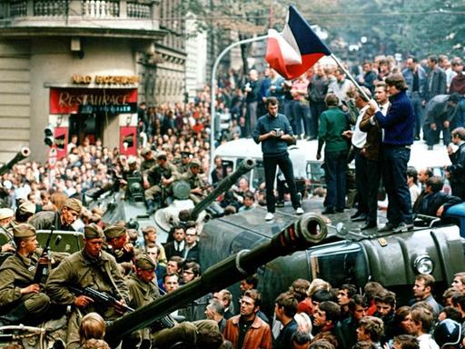 August 1968, Tschechoslowakei, Prag: Protestierer umringen in der Innenstadt sowjetische Panzer und stehen mit einer Fahne der Tschechoslowakei auf einem umgekippten Militärfahrzeug.