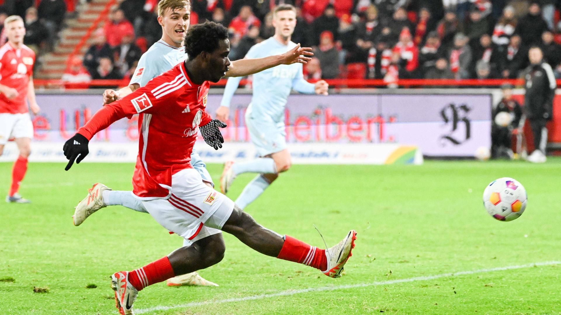 Ein Fußballer zielt aufs Tor. Im Hintergrund sind weitere Spieler zu erkennen.