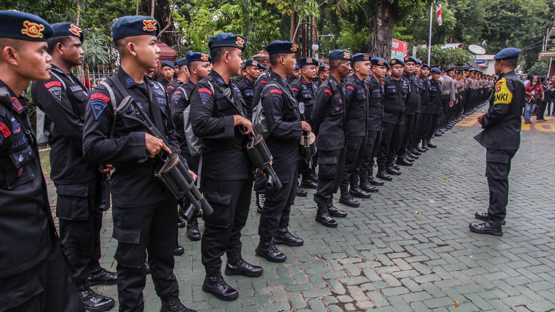 Indonesische Polizisten stehen zur Inspektion durch einen Vorgesetzten in einer Reihe. Indonesische Polizisten stehen zur Inspektion durch einen Vorgesetzten in einer Reihe.