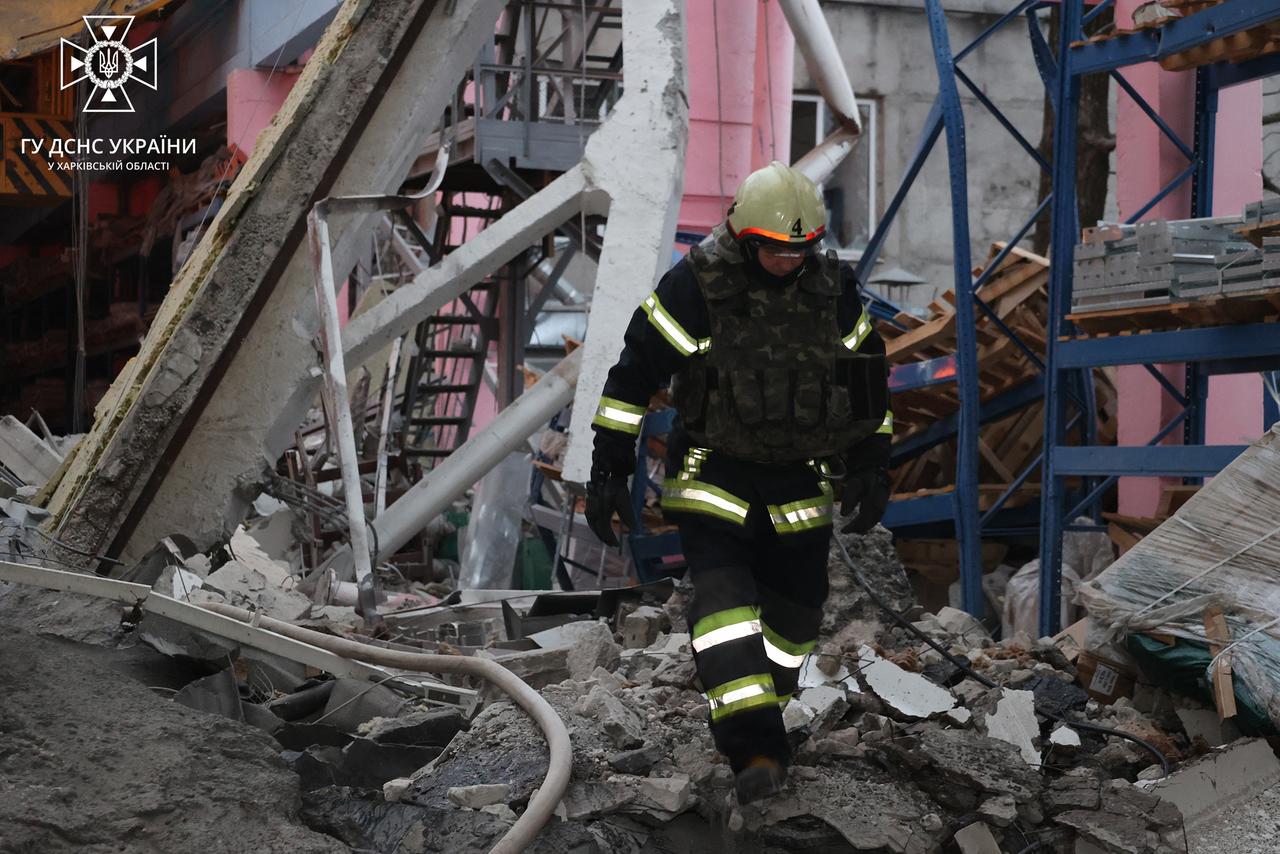 Ein Feuerwehrmann vor dem Stahlgerippe eines zerstörten Gebäudes.