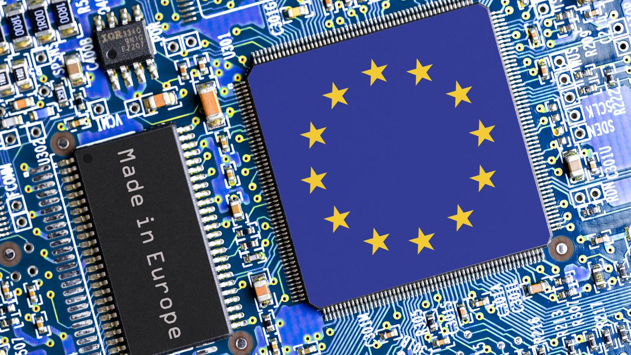 Eine blaue Platine mit diversen Halbleitern und zwei Chips. Einer trägt die Aufschrift "Made in Europe", der andere, größere, zeigt die Flagge der EU