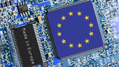 Eine blaue Platine mit diversen Halbleitern und zwei Chips. Einer trägt die Aufschrift "Made in Europe", der andere, größere, zeigt die Flagge der EU