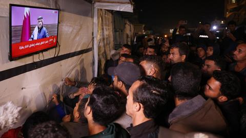 Menschen verfolgen die Live-Übertragung einer Pressekonferenz des katarischen Premierministers al Thani in Chan Yunis im südlichen Gazastreifen.