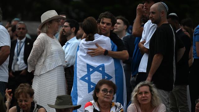 Eine Gruppe von Menschen. 2 Menschen umarmen sich. 