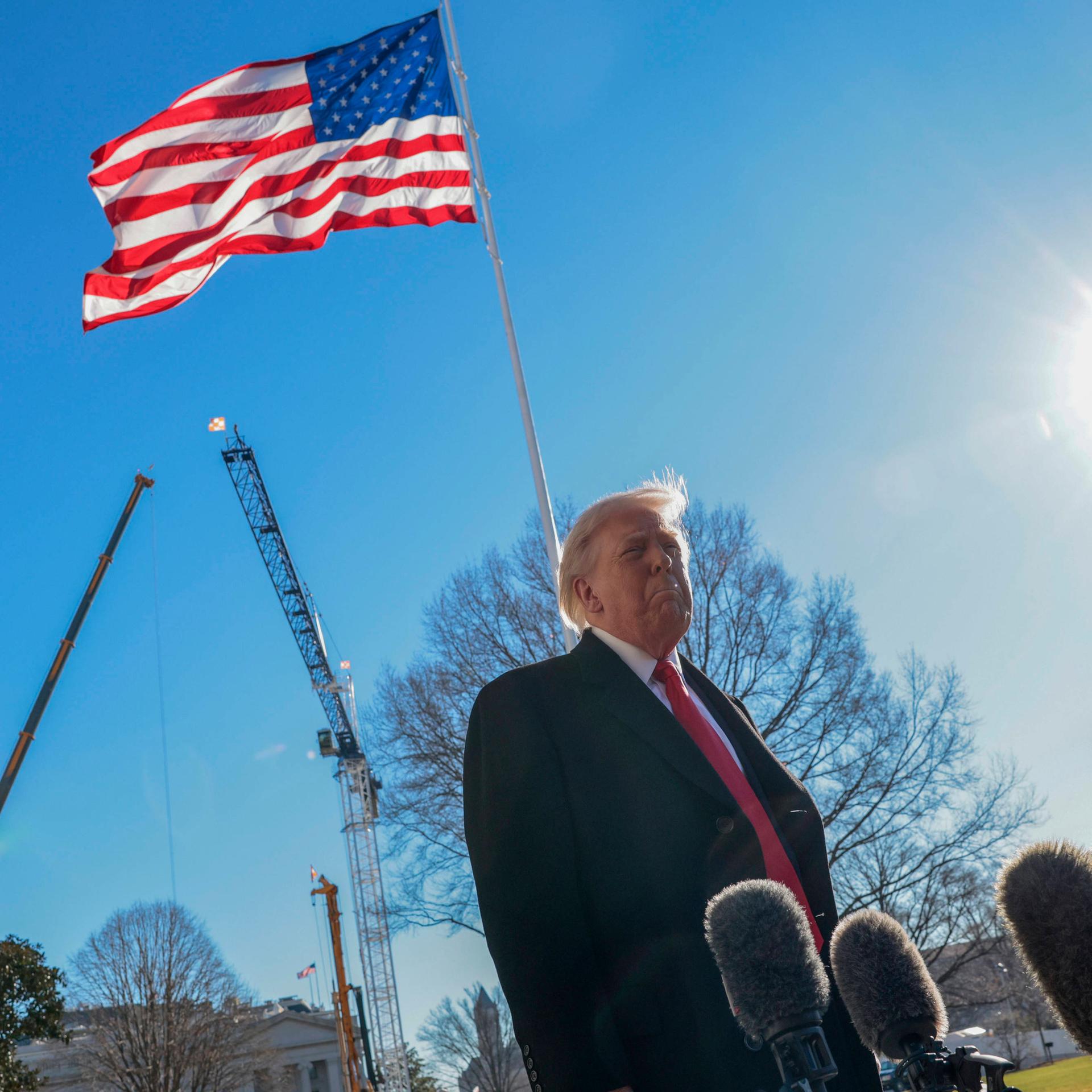 Donald Trump steht vor Mikrofonen am Weißen Haus, im Hintergrund sind die Baukräne für den Umbau seines geplanten Ballsaales zu sehen.