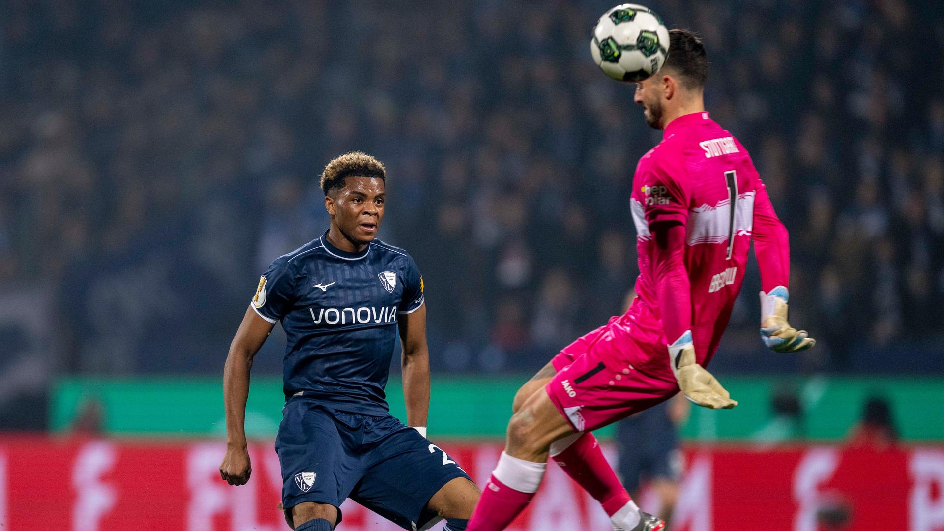 Farid Alfa-Ruprecht (VfL Bochum) (l) und Torwart Fabian Bredlow (VfB Stuttgart) kämpfen um den Ball.