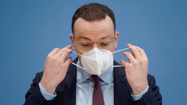 Jens Spahn beim Aufsetzen seiner FFP2-Maske bei der Bundespressekonferenz zum Thema Corona-Lage im Jahr 2021.