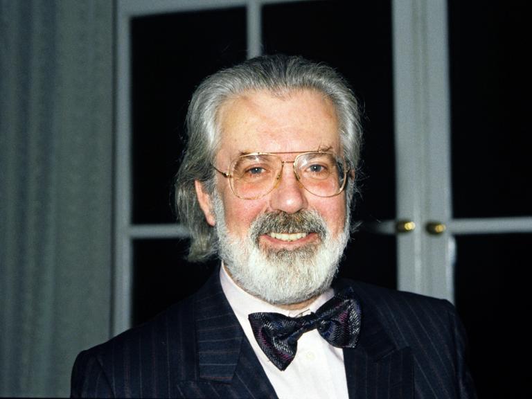 Der Kinderbuchautor Michael Ende im schwarzen Anzug, mit schwarzer Fliege und grauem Bart. 