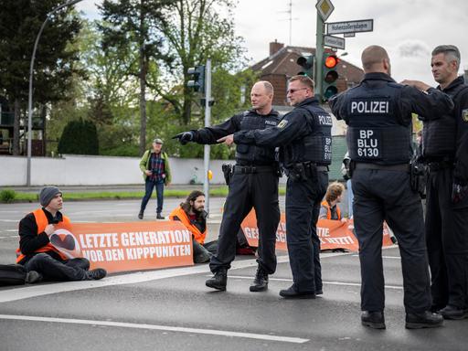 Polizisten besprechen die Vorgehensweise zur Räumung der Kreuzung Hohenzollerndamm/Konstanzer Straße, wo Aktivisten auf der Fahrbahn sitzen.