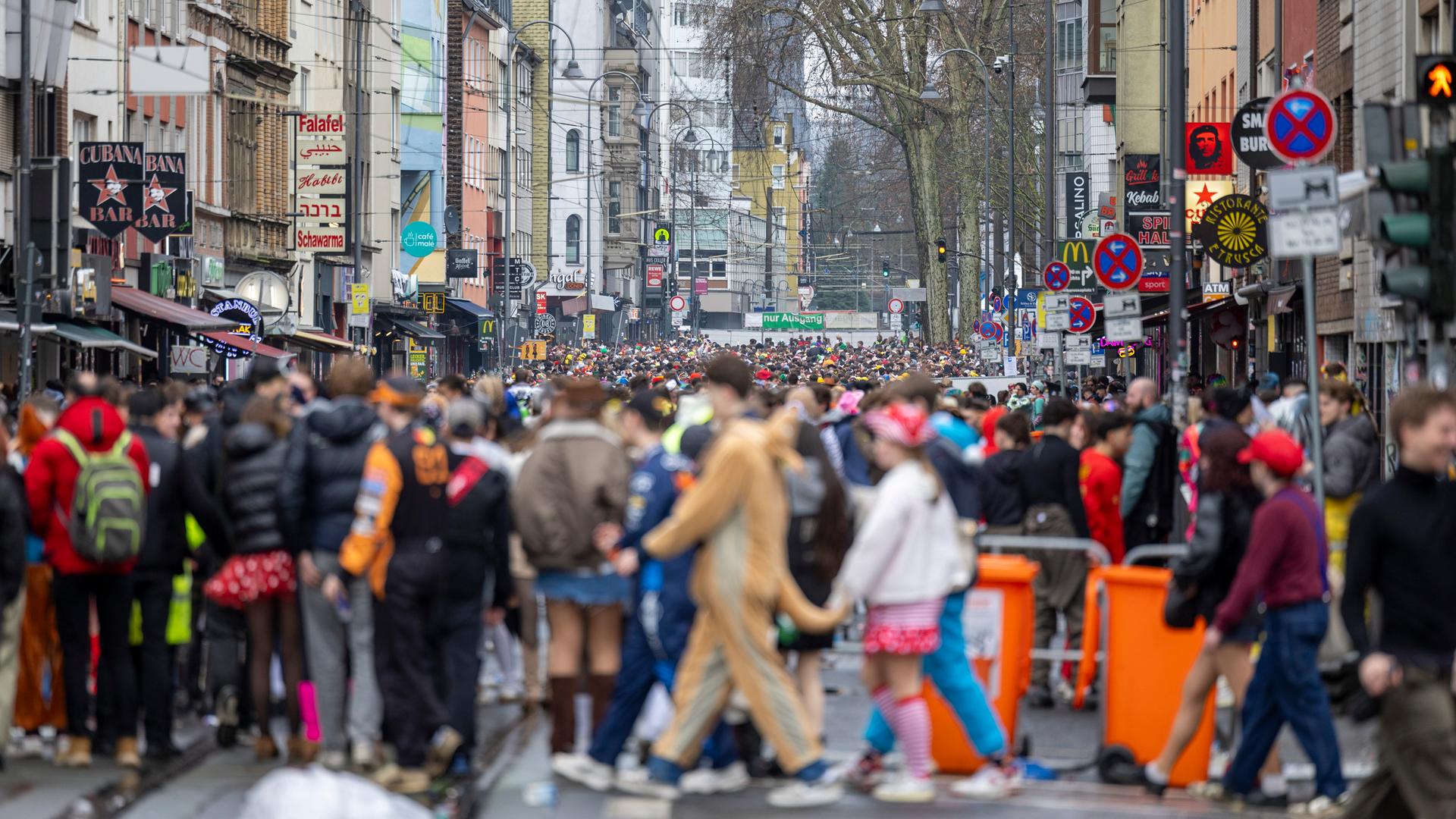 Karnevalisten feiern trotz Regens auf der Zülpicher Straße in Köln. 
