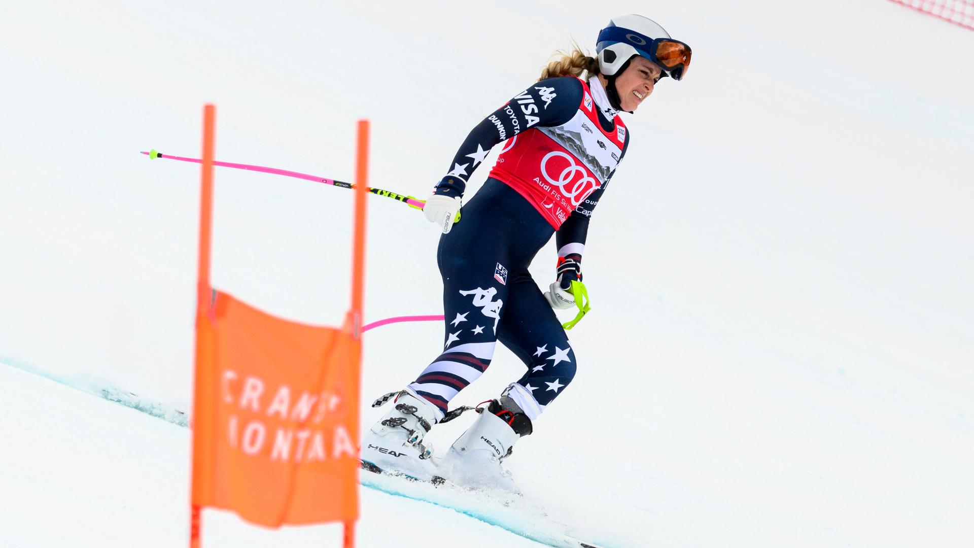 Lindsey Vonn fährt mit schmerzverzerrtem Gesicht auf Skiern die Piste herunter. 