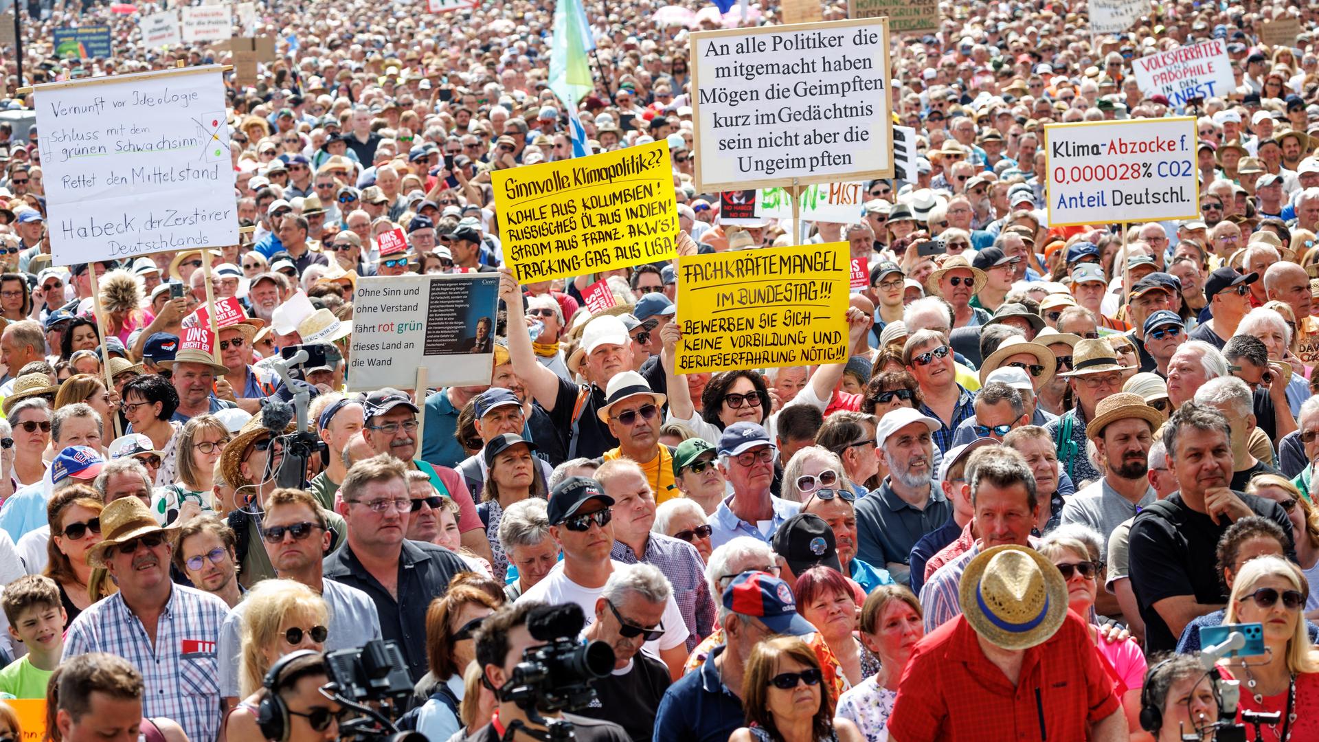 Teilnehmer halten bei einer Demonstration gegen die Klima-Politik der Ampelregierung unter dem Motto "Stoppt die Heizungsideologie" Schilder mit Aufschriften wie "Vernunft vor Ideologie - Schluss mit dem grünen Schwachsinn!" in die Höhe.