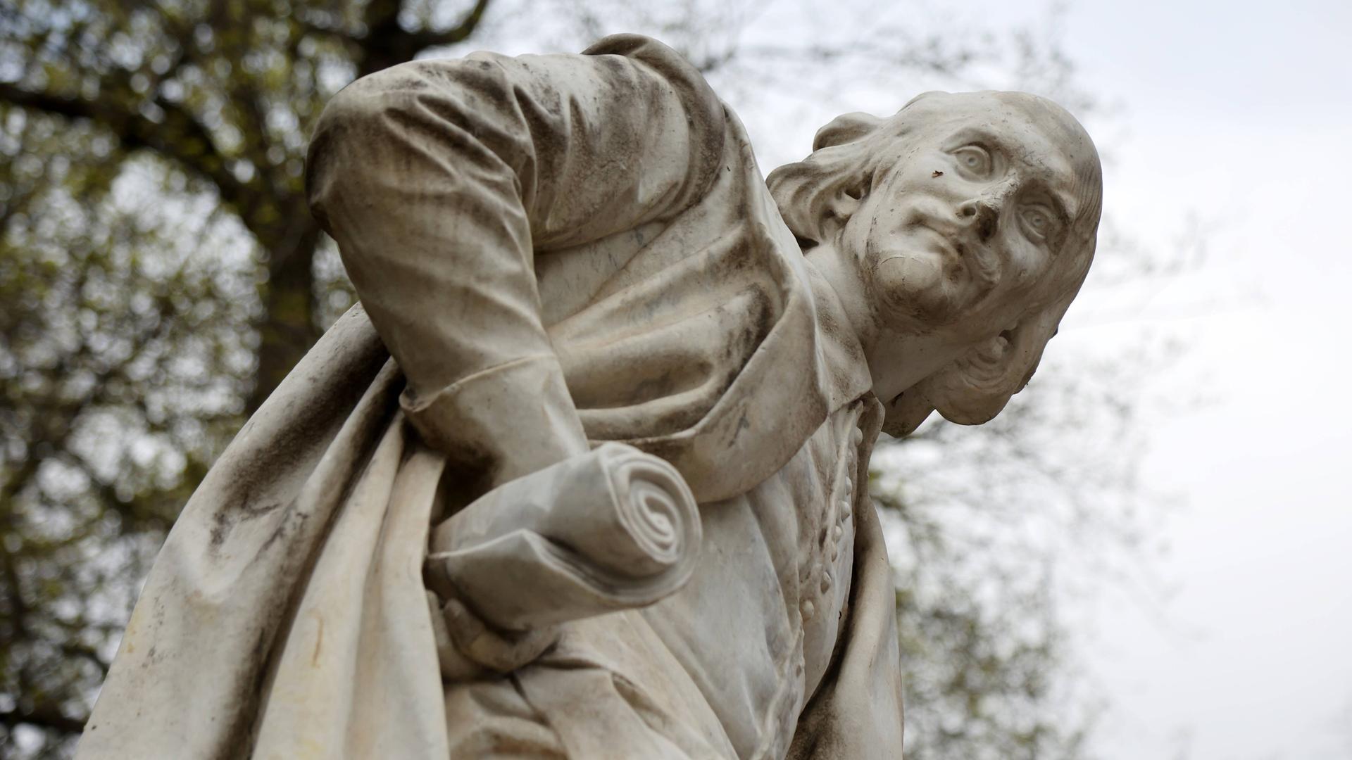 Weißes William Shakespeare Denkmal im Park an der Ilm in Weimar, auf dem die Figur mit einer Skriptrolle in der rechten Hand des angewinkelten Arms nach unten in die Kamera blickt. Weißes William Shakespeare Denkmal im Park an der Ilm in Weimar, auf dem die Figur mit einer Skriptrolle in der rechten Hand des angewinkelten Arms nach unten in die Kamera blickt.