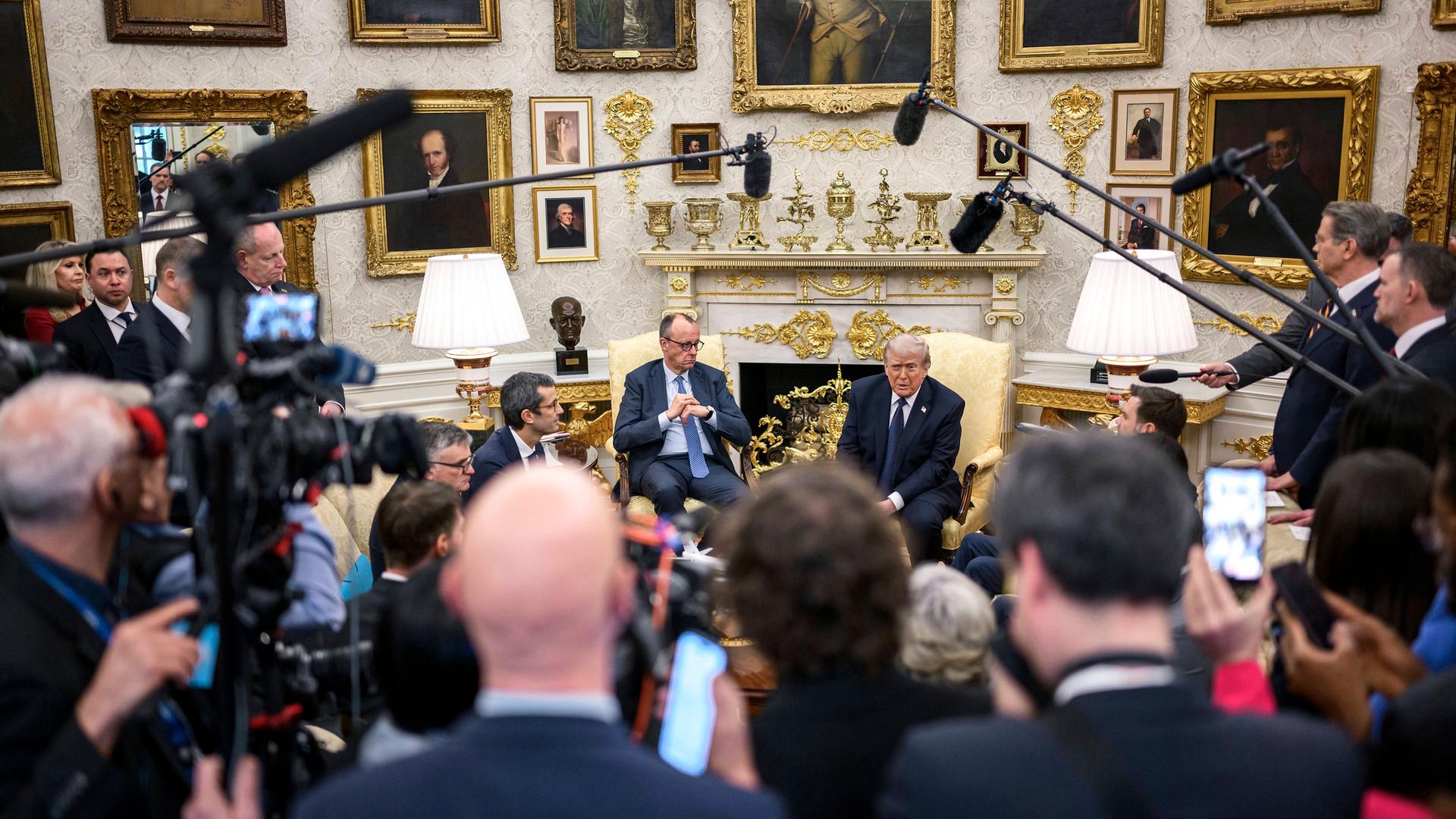 U.S Präsident Donald Trump empfängt Bundeskanzler Friedrich Merz im Weißen Haus, dahinter Journalisten mit Mikrofonangeln