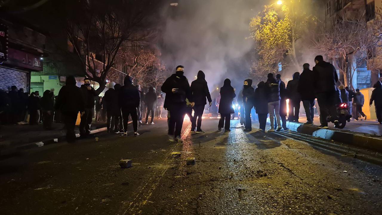 Auf diesem Bild vom 9.1. aus Teheran sind zahlreiche Protestierende zu erkennen. Es ist Nacht, auf der Straße spiegelt sich das Licht. Die Personen sind vermummt. Auf diesem Bild vom 9.1. aus Teheran sind zahlreiche Protestierende zu erkennen. Es ist Nacht, auf der Straße spiegelt sich das Licht. Die Personen sind vermummt.
